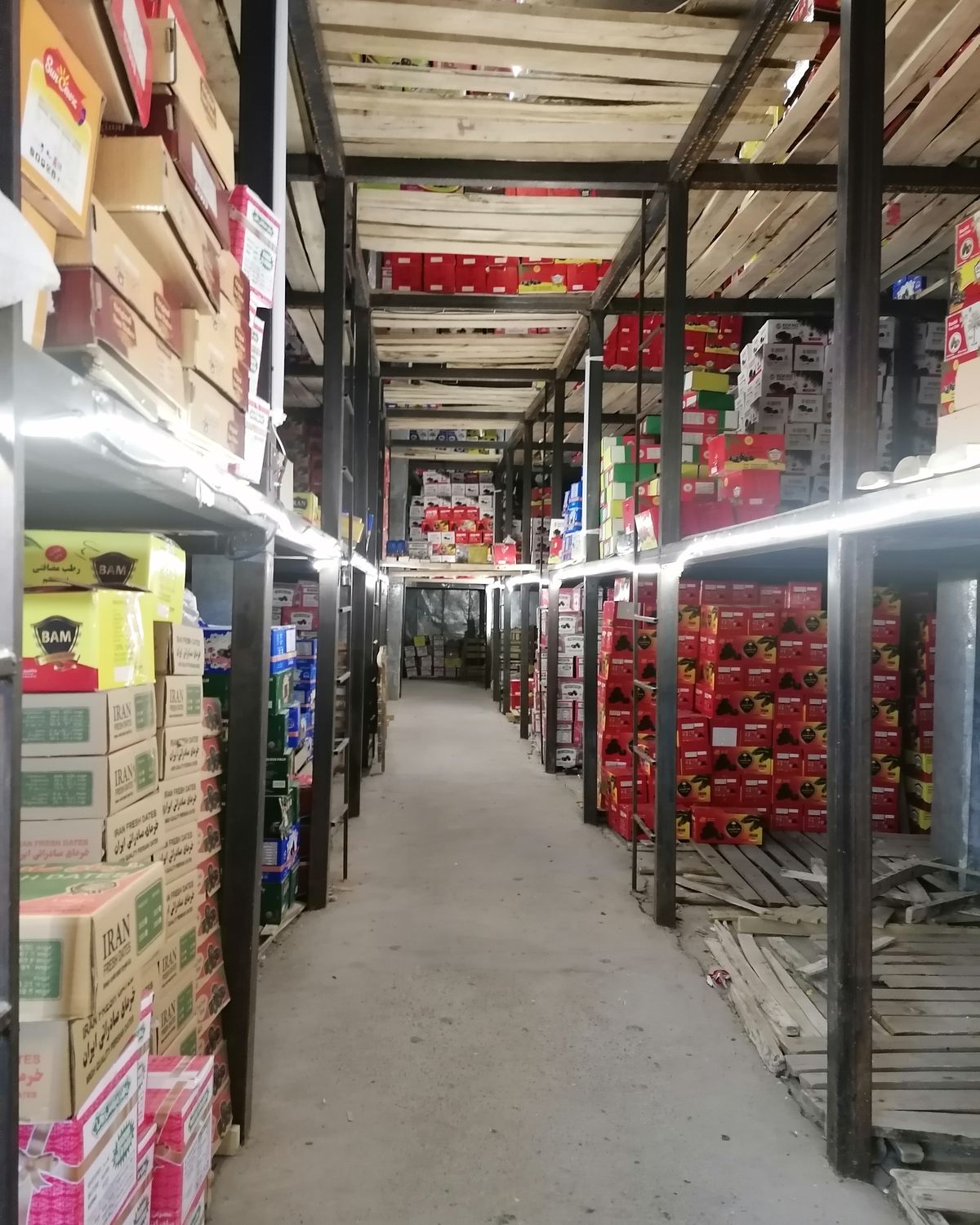 Cold-storage aisle stacked with packed date cartons in Bam